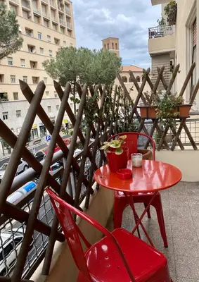 a red table and chairs on a balcony at MM Ma Maison in Rome