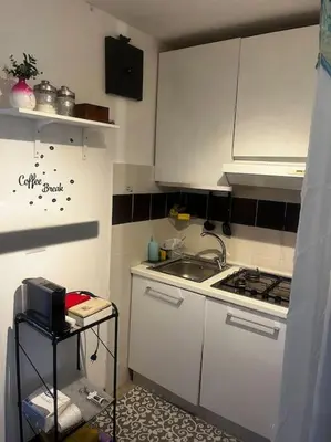 a small kitchen with white cabinets and a sink at Ranieri casa vacanze in Rome