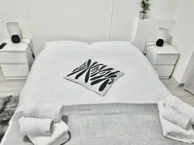 a white bedroom with a bed with aania sign on it at Domus Euclide in Rome