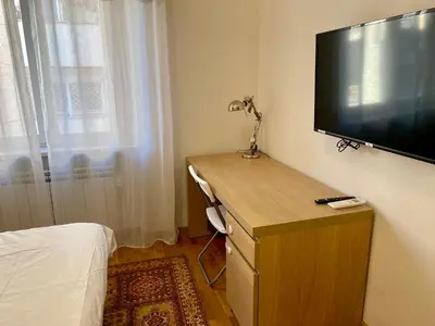 a bedroom with a desk with a television on a wall at ARCA LUXURY HOME in Rome