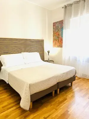 a bedroom with a large bed with a wooden floor at ARCA LUXURY HOME in Rome