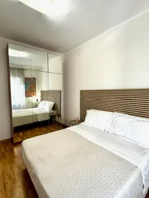 a bedroom with a large white bed and a mirror at ARCA LUXURY HOME in Rome