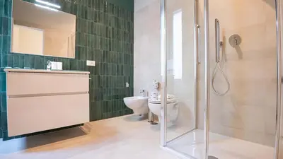 a bathroom with a toilet and a glass shower at EasyTopStay - Crescenzio Elegant Apartment in Rome