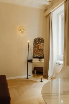 a living room with a chair and a glass table at Restart Accommodations Tritone in Rome