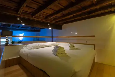 a bedroom with a large white bed with towels on it at Restart Accommodations Nettuno in Rome