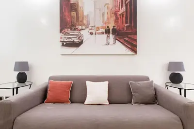 a living room with a couch and a painting on the wall at Restart Accommodations Nettuno in Rome