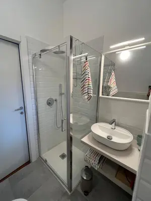 a bathroom with a glass shower and a sink at La casa di Monica appartamento Ostiense Roma in Rome