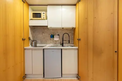 a small kitchen with white cabinets and a sink at Pearl of Circo Massimo in Rome