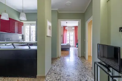 a kitchen with green walls and a flat screen tv at Casa Preziosa in Metro Piramide in Rome
