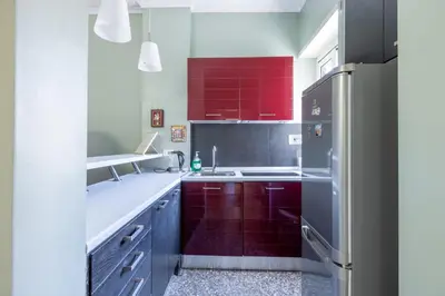 a kitchen with red cabinets and a refrigerator at Casa Preziosa in Metro Piramide in Rome
