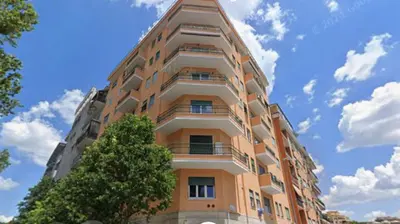 a tall building with a tree in front of it at Bright and cozy apartment near the Vatican city in Rome
