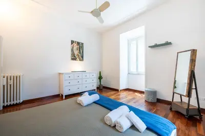 a bedroom with a bed and a dresser with towels at Elegante Appartamento con Giardino, Vicino al Centro di Roma e Stadio Olimpico in Rome