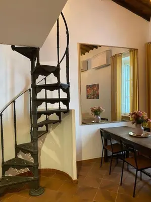 a spiral staircase in a living room with a table at Home Bella Roma centro storico in Rome