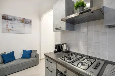 a kitchen with a stove top oven next to a couch at White Flat San Lorenzo in Rome