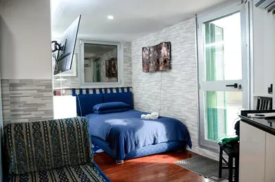 a bedroom with a blue bed and a window at Magnifico 122 Apartment in Rome