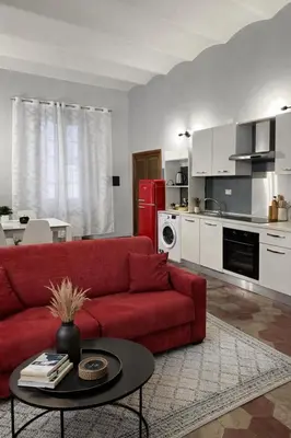 a living room with a red couch and a kitchen at Ale home in Rome