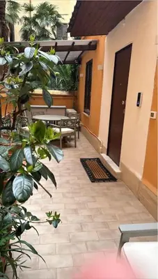 a patio with benches and a table and a plant at Cola di Rienzo 243 Relais-B in Rome