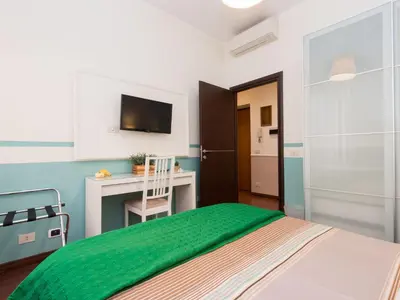 a bedroom with a bed and a desk and a television at Apartment Vatican - Residenza Argilla by Interhome in Rome