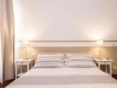 a bedroom with a bed with two nightstands and two lamps at Apartment Vatican - Residenza Argilla by Interhome in Rome