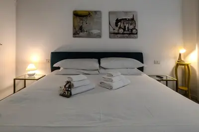 a white bed with towels and a doll sitting on it at Restart Accommodations Trevi in Rome