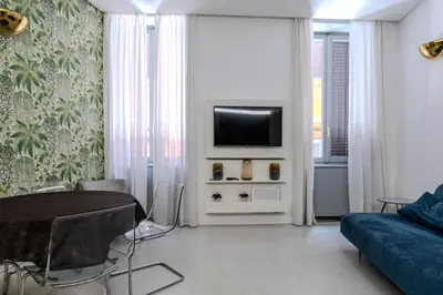 a living room with a blue couch and a tv at Restart Accommodations Trevi in Rome