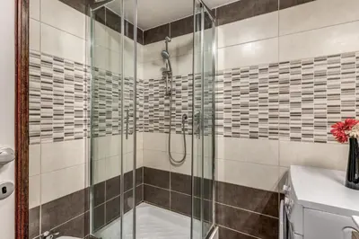 a bathroom with a shower with a glass door at M&L Apartments - Ardesia Colosseo in Rome