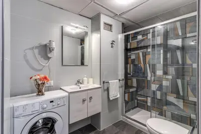 a bathroom with a washing machine and a shower at M&L Apartments - Ardesia Colosseo in Rome