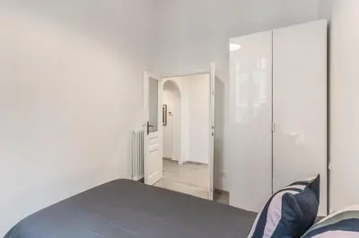 a bedroom with white walls and a large mirror at Supernova Apartment Trastevere in Rome