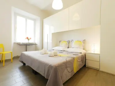 a bedroom with a large bed with yellow and white pillows at Movie Apartment in Rome