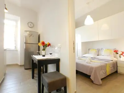 a bedroom with a bed and a table and a refrigerator at Movie Apartment in Rome