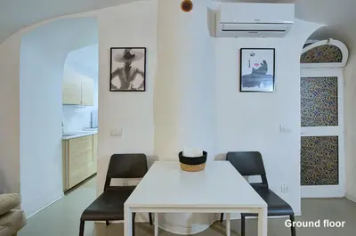 a white dining room with a white table and chairs at Casa a Monti in Rome