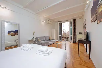 a white bedroom with a bed and a living room at La Civetta a Navona in Rome