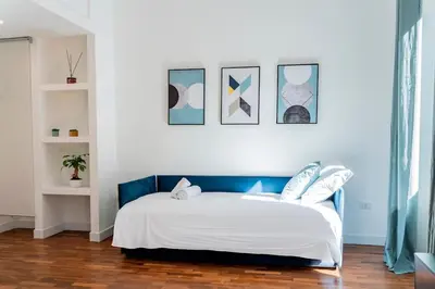a bedroom with a white bed with a blue headboard at Domina Apartments Roma - San Pietro 1 in Rome
