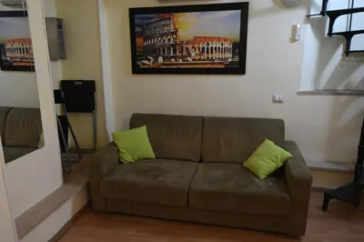 a couch in a living room with two green pillows at Holiday City Center in Rome