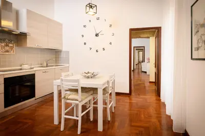 a kitchen with a table and a clock on the wall at Mommy's - Vatican House in Rome