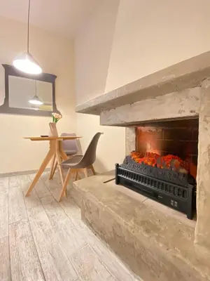 a living room with a fireplace and a table at Tiziano's house San Pietro Station in Rome