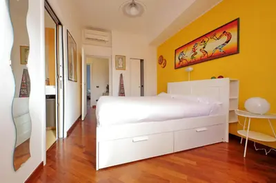 a bedroom with a white bed and a yellow wall at YCH-Una finestra sulla Cupola di San Pietro in Rome