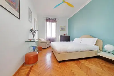 a bedroom with a white bed and a wooden floor at YCH-Una finestra sulla Cupola di San Pietro in Rome