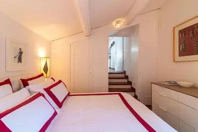 a bedroom with a white bed and a staircase at Campo de' Fiori Enchanting Attic in Rome