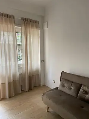a living room with a couch and a window at ALMA - Vatican Apartment in Rome