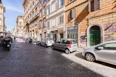 a cobblestone street with parked cars and buildings at URBANA 18 in Rome