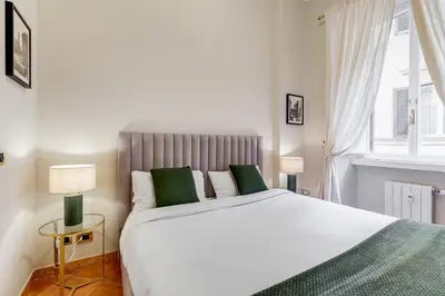 a bedroom with a large white bed with green pillows at URBANA 18 in Rome
