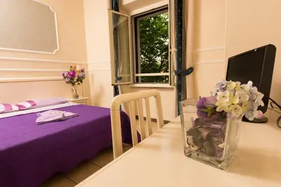 a room with a table with a vase of flowers at Allegria Fitzroy Cesar in Rome