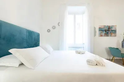 a white bed with two towels on top of it at Trastevere Exclusive Three Bedroom Apartment in Rome