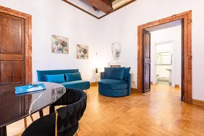 a living room with a blue couch and a table at Spanish Steps Exclusive Apartment in Rome