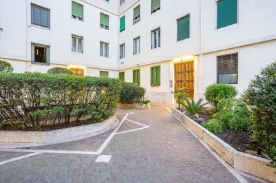 a courtyard of a building with a gate and bushes at Maximo Luxe -Villa & Apartment in Rome