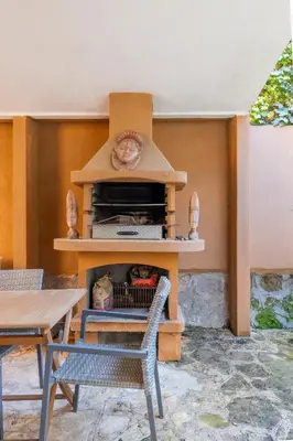 a stove in a patio with a table and chairs at Maximo Luxe -Villa & Apartment in Rome