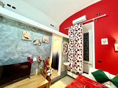 a living room with a red wall and a tv at B&B Termini Colosseo Suite in Rome