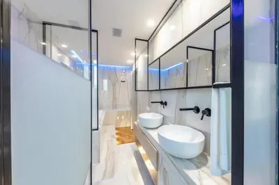 a bathroom with two white sinks and mirrors at Blue Inn Luxury Suites in Rome