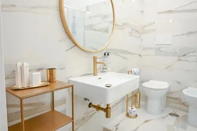 a white bathroom with a sink and a mirror at Via Veneto 116 Suites - Guest House in Rome